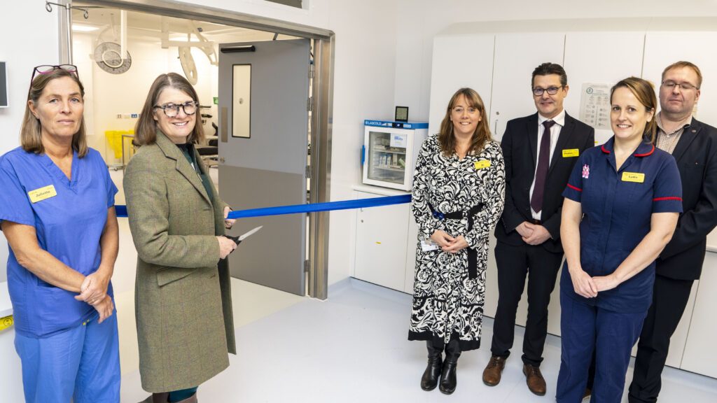 Rachel Maclean MP cutting the ribbon to mark the full opening of the theatre complex, stood alongside staff from the Alexandra Hospital.