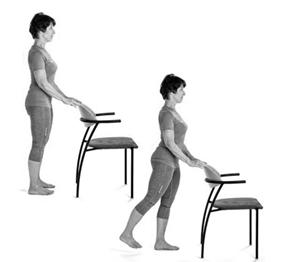 A picture of a person standing behind the chair, slowly straighten your leg behind you, keeping the knee straight and pointing forwards