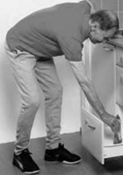 A picture of a person reaching down to a drawer