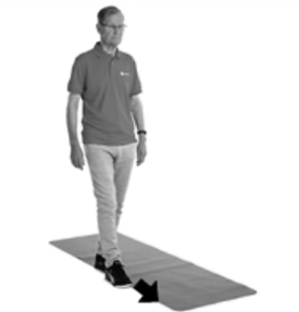 A picture of a person walking slowly along the edge of a carpet