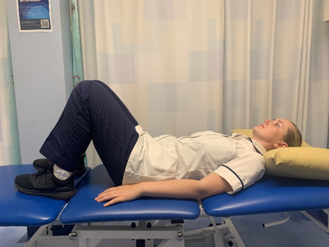 A picture of a person lying on their back on a bed with their knees bent