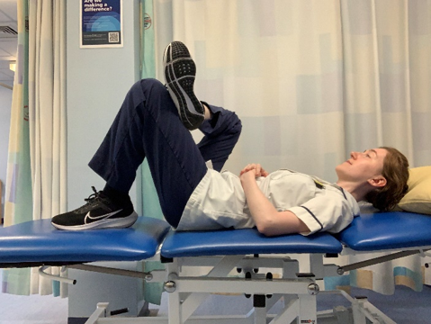 A picture of a person lying on their back on a bed, bend up the knee on the opposite side to draw the foot closer towards you.