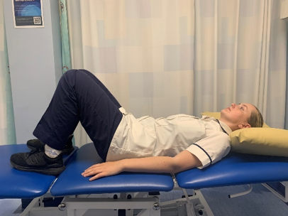 A picture of a person lying on their back on a bed with their knees bent