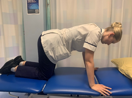 A person on hands and knees on the bed. 
