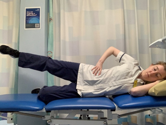 A picture of a person lying on their side. Placed the upper hand on the hip. Bend the knee of the lower leg. Keeping your knee straight, slowly raise the upper leg away from the other.