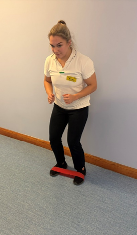 A picture of a person with a looped exercise band round the feet.