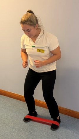 A picture of a person bending slightly at the hips and knees, with a small forwards lean at the trunk. Take a step out to one side and continue stepping in this direction against the band. Complete both directions.