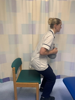 A picture of a person, leaning forwards to stand up whilst holding the weight.