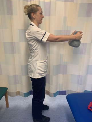 A picture of a person stretching arms outwards whilst holding a weight in the hands